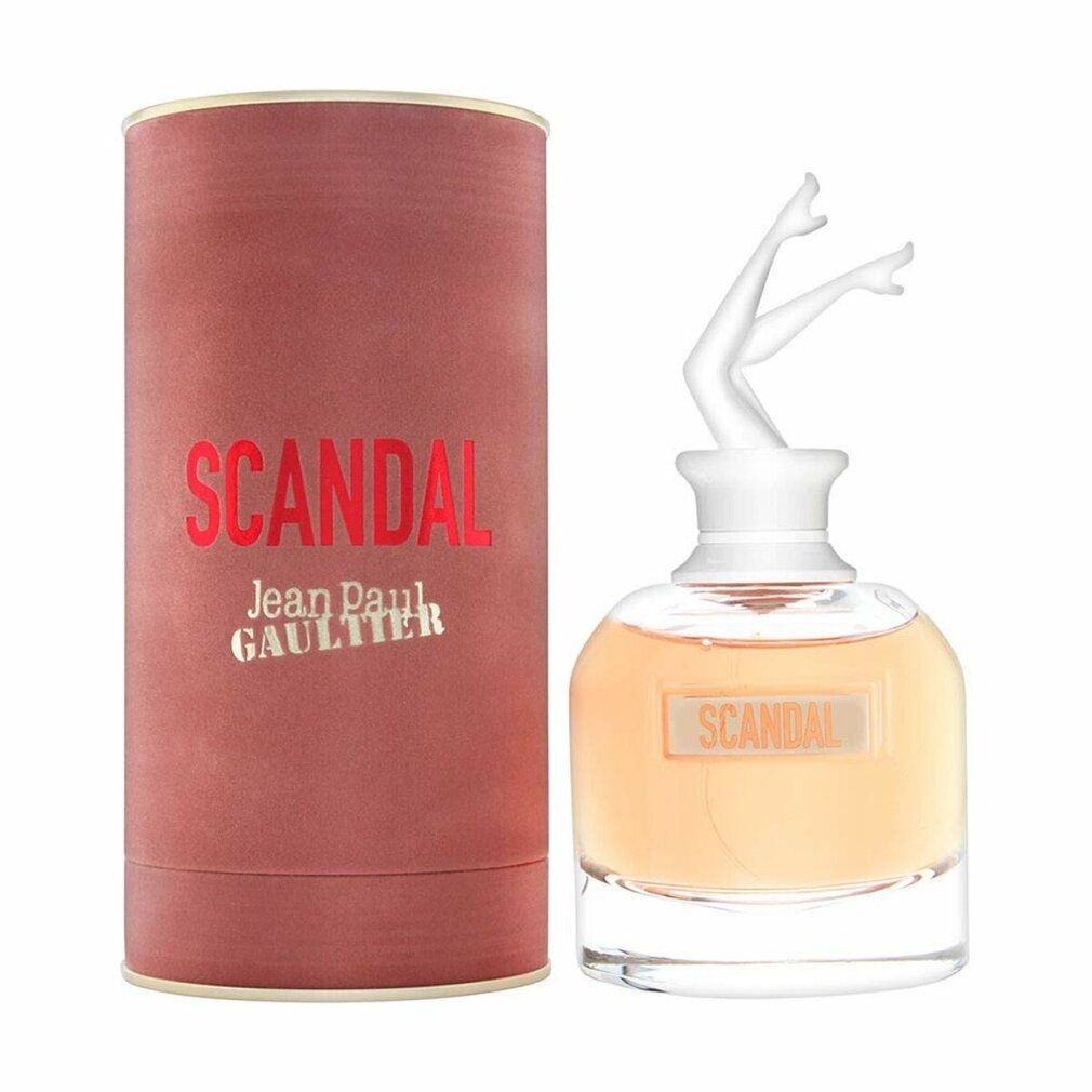 Flacone di profumo con tappo a forma di gambe bianche e confezione cilindrica. Scritta "SCANDAL" e "Jean Paul Gaultier".