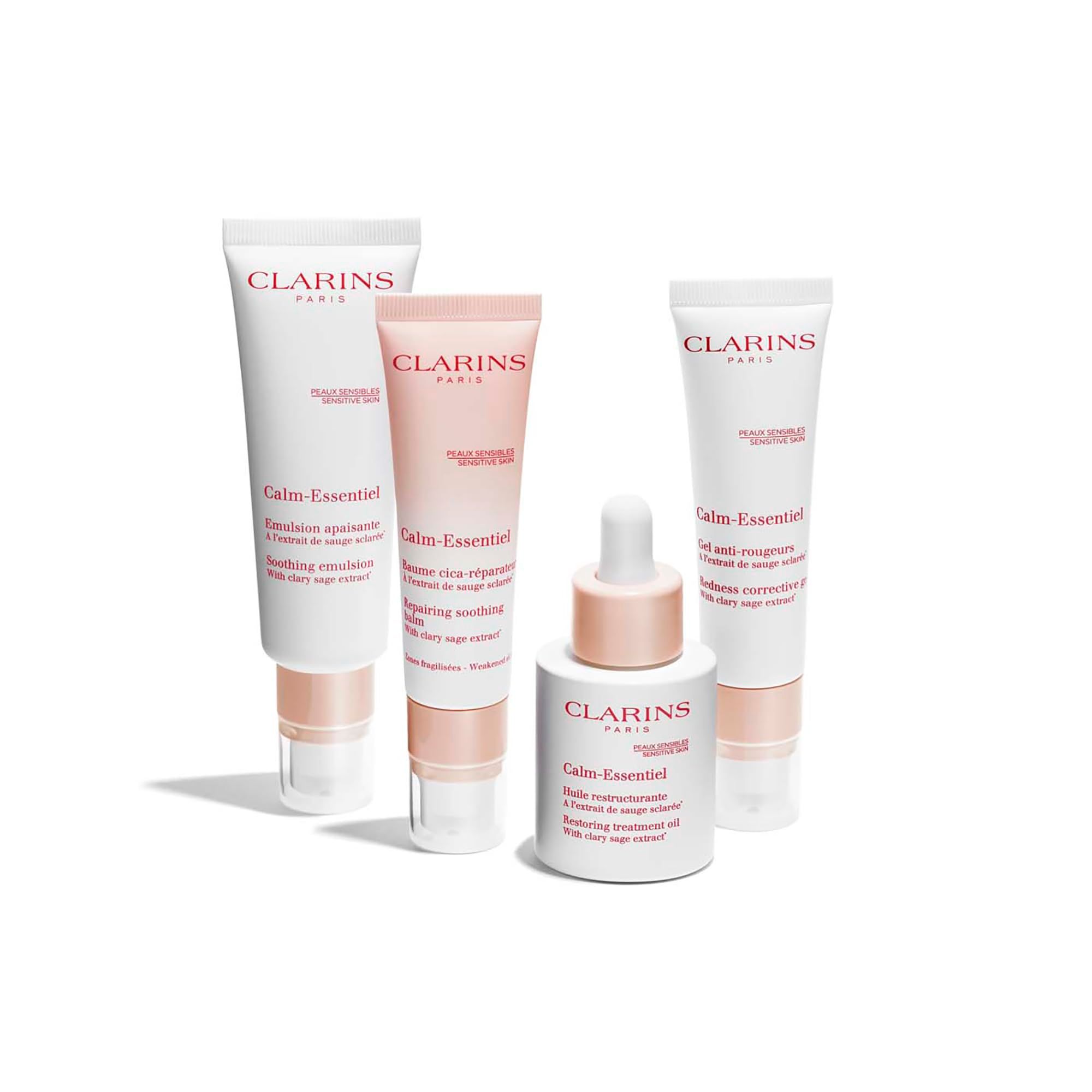 Quattro prodotti CLARINS Calm-Essentiel. Emulsione, siero, gel e olio. Tubi e flacone bianco-rosa. Testo: Calm-Essentiel.