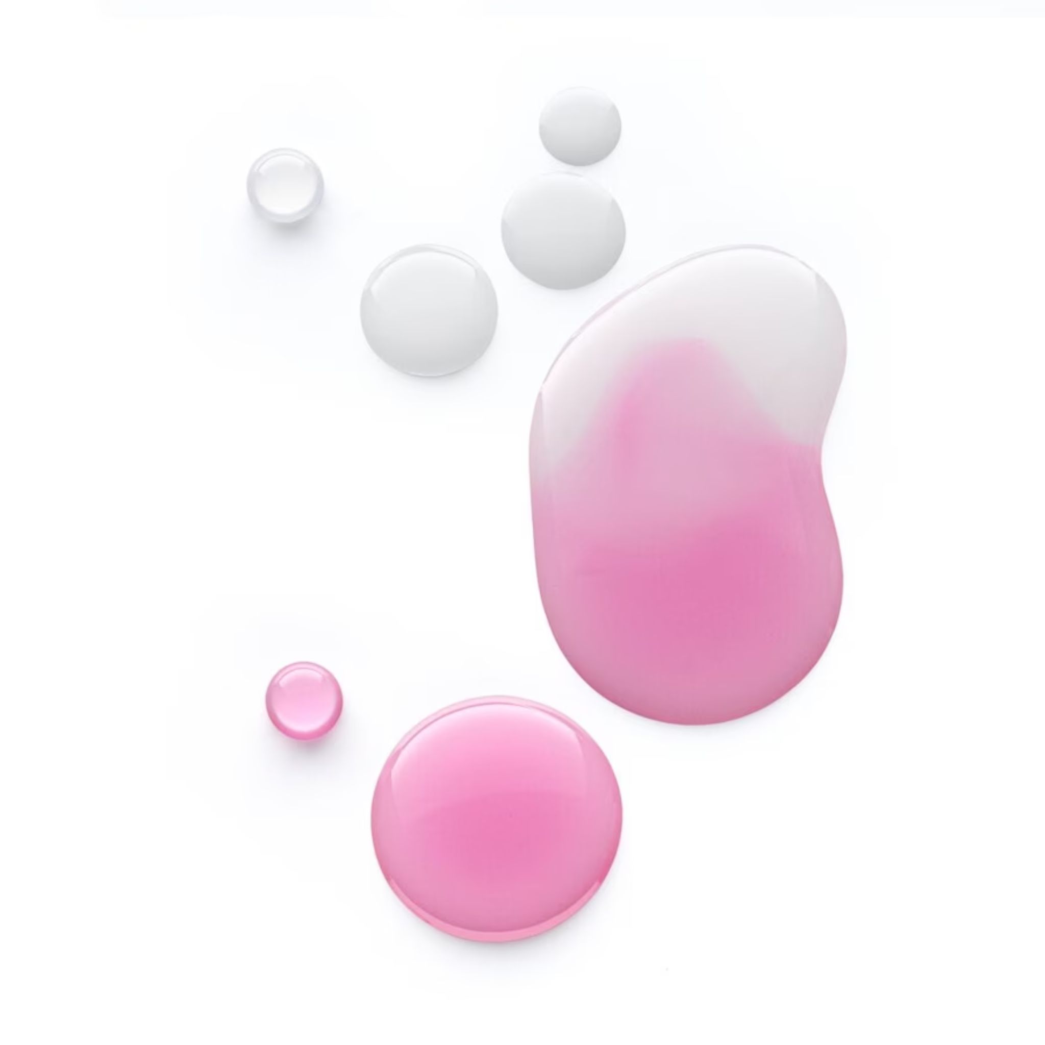Gocce rosa e trasparenti su sfondo bianco. Diverse dimensioni e forme. Alcune gocce sono colorate di rosa.