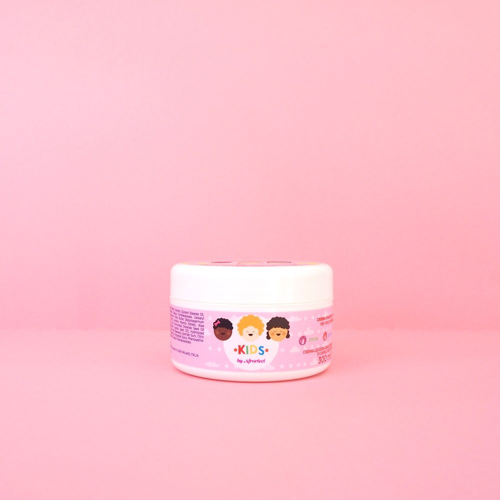 Vasetto bianco con etichetta rosa. Scritta: Kids by Afroricci. Posto su sfondo rosa.