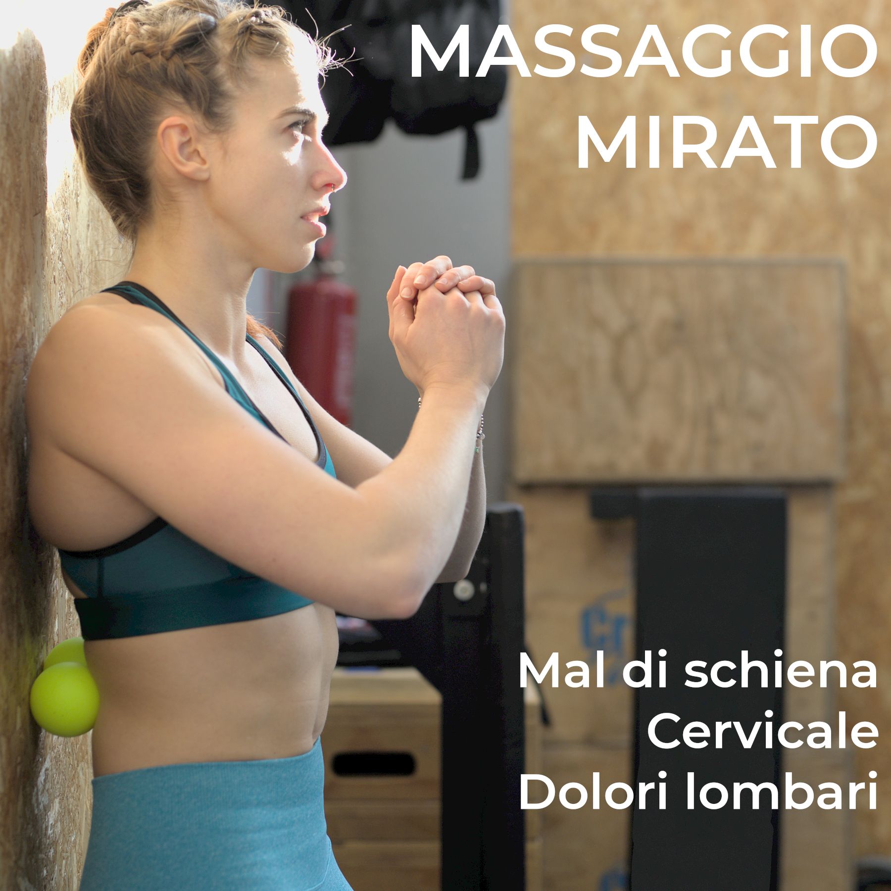 Donna usa pallina da massaggio gialla per la zona lombare contro un muro.