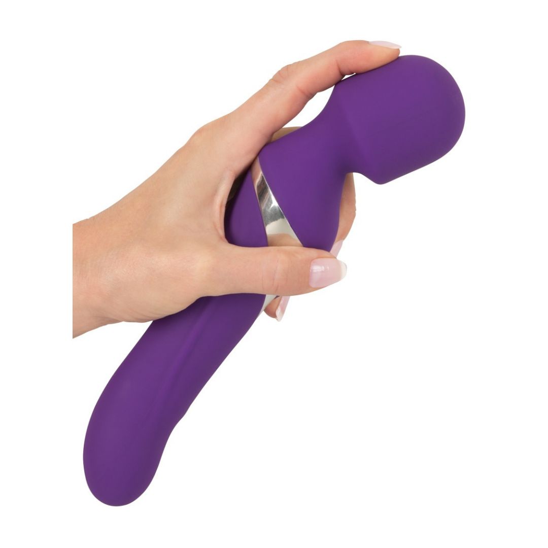 Vibratore viola, tenuto in mano. Dettaglio argentato. Forma arrotondata con una testa.