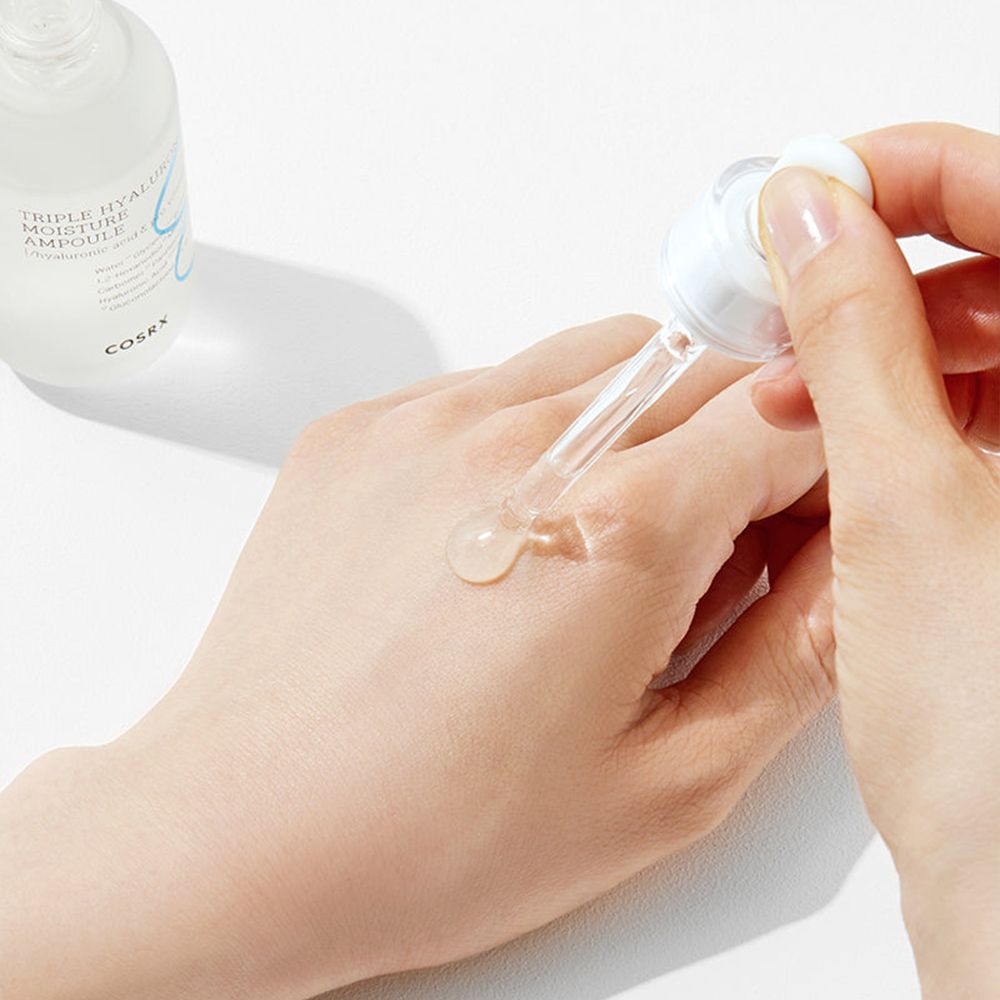 COSRX Triple Hyaluronic Moisture Ampoule applicata su una mano.