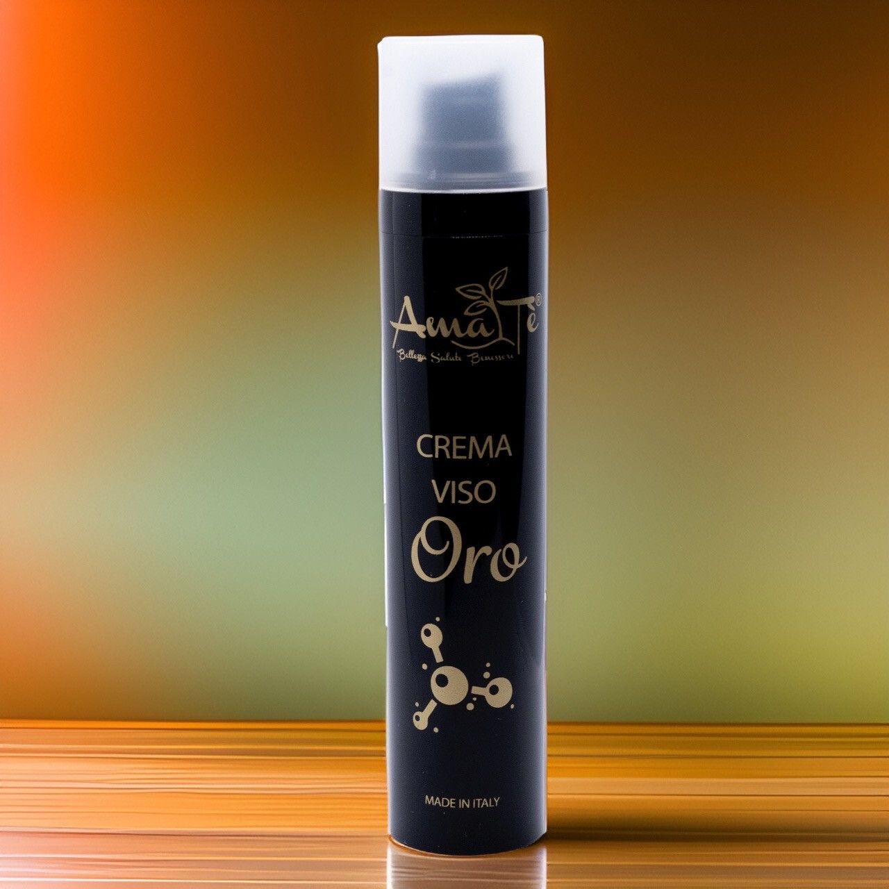 Flacone nero con testo dorato. Scritta: Amatè Crema Viso Oro. Made in Italy. Erogatore bianco. Sfondo sfumato.