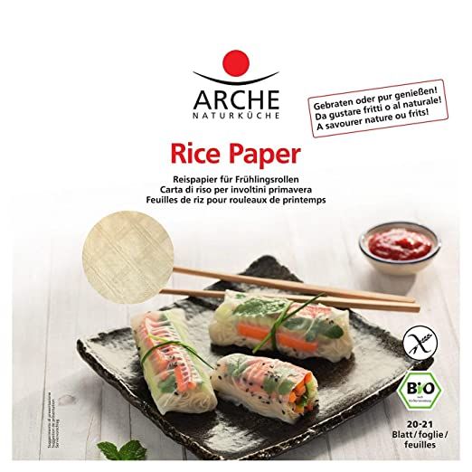 Confezione di carta di riso Arche con tre involtini primavera su un piatto, bacchette e salsa.