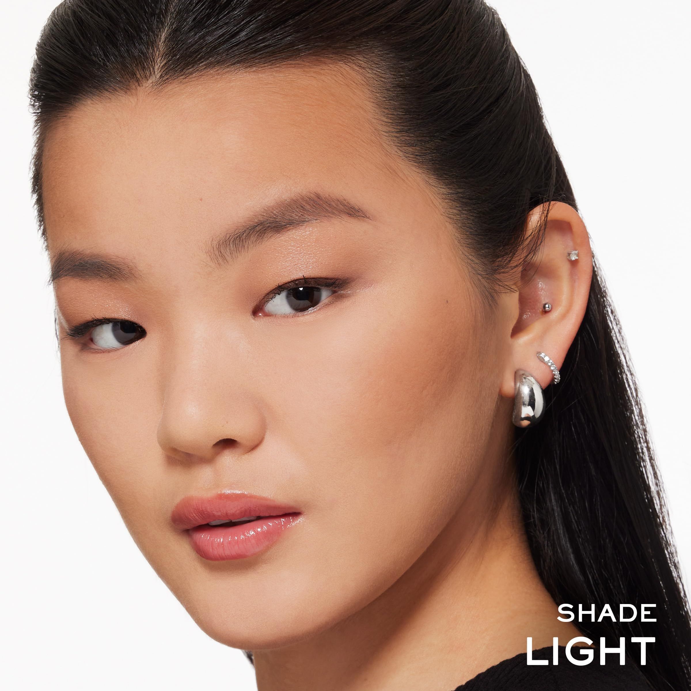 Volto di donna con incarnato chiaro. Sulla pelle è applicato un bronzer. Sotto il mento c'è scritto "SHADE LIGHT".