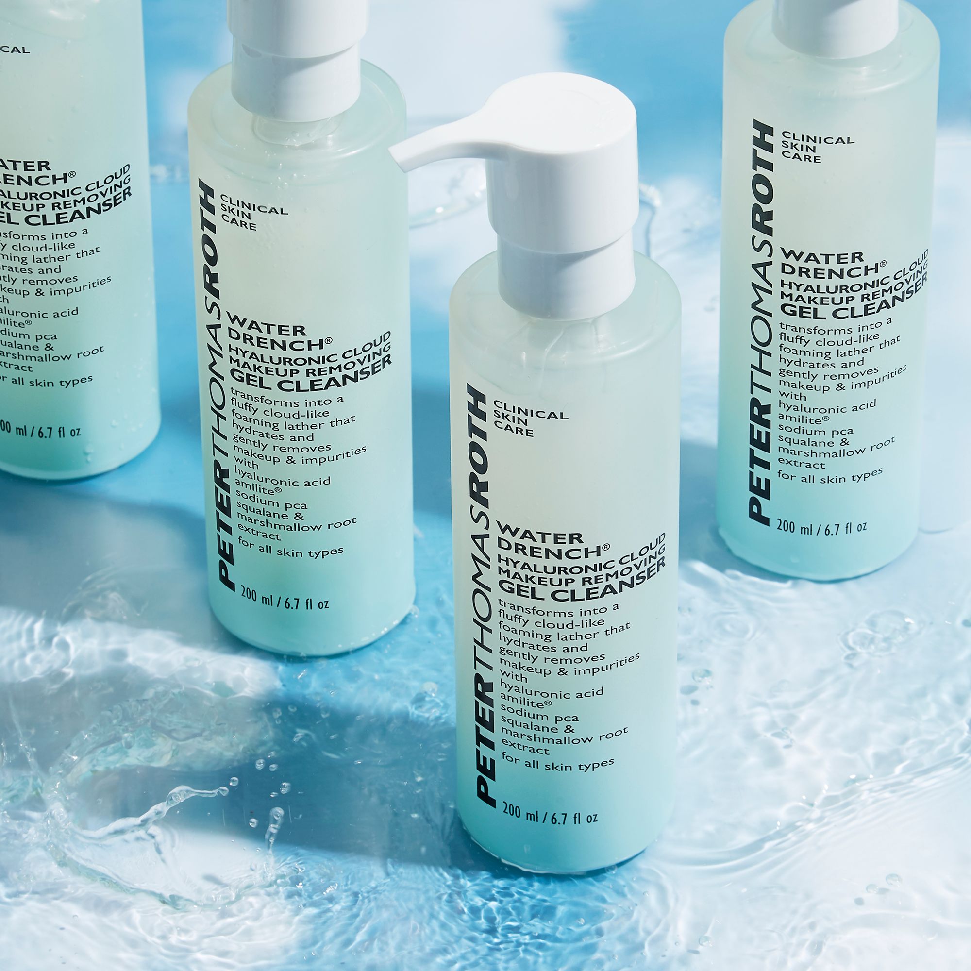 Più flaconi di detergente per il viso con dosatore. Scritta: Water Drench Hyaluronic Cloud. Flaconi azzurri.