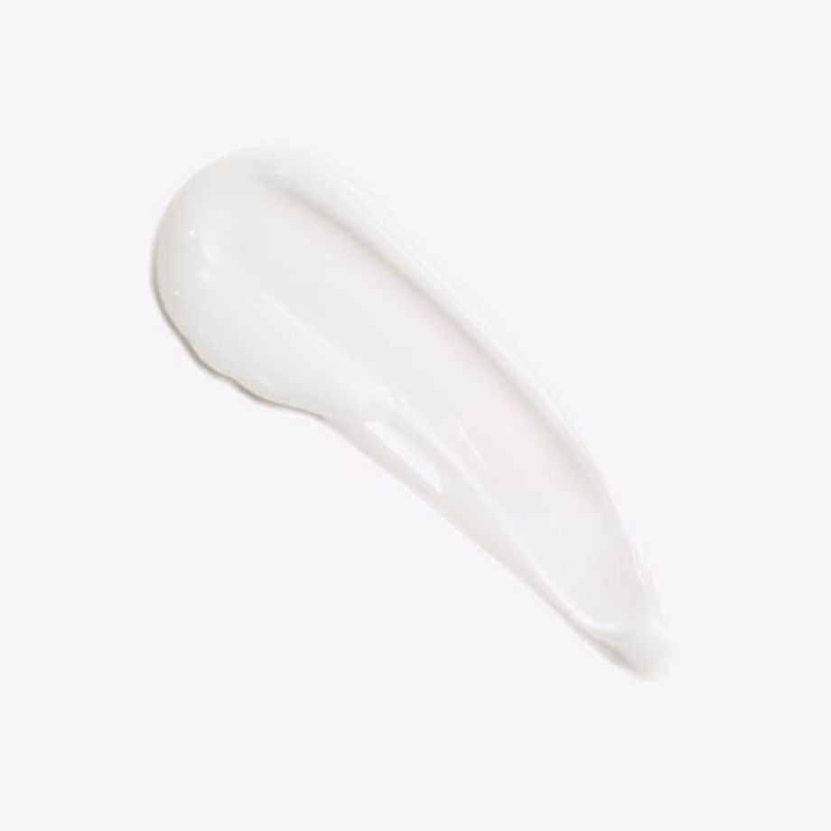 Traccia di crema bianca su sfondo chiaro. Consistenza visibile.