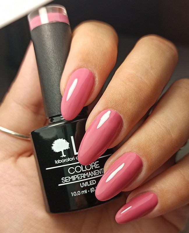 Mano con unghie rosa smaltate, accanto a flacone di smalto. Scritta: LCI, Colore Semipermanente, UVLED 10,0 ml.