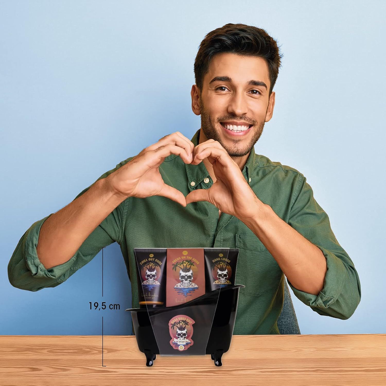 Uomo che mostra un gesto del cuore. Set in una vasca da bagno nera. Contiene gel doccia, lozione e sale da bagno. 19,5 cm di altezza.