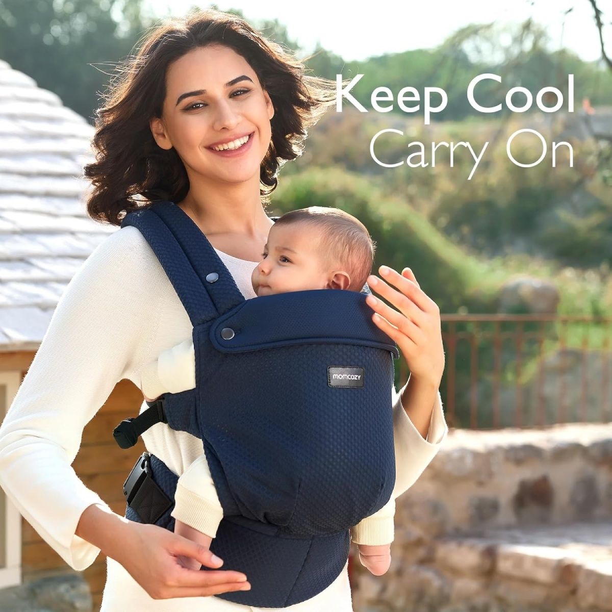 Donna con bambino nella fascia portabebè blu. Logo Momcozy visibile. Testo: Keep Cool Carry On.