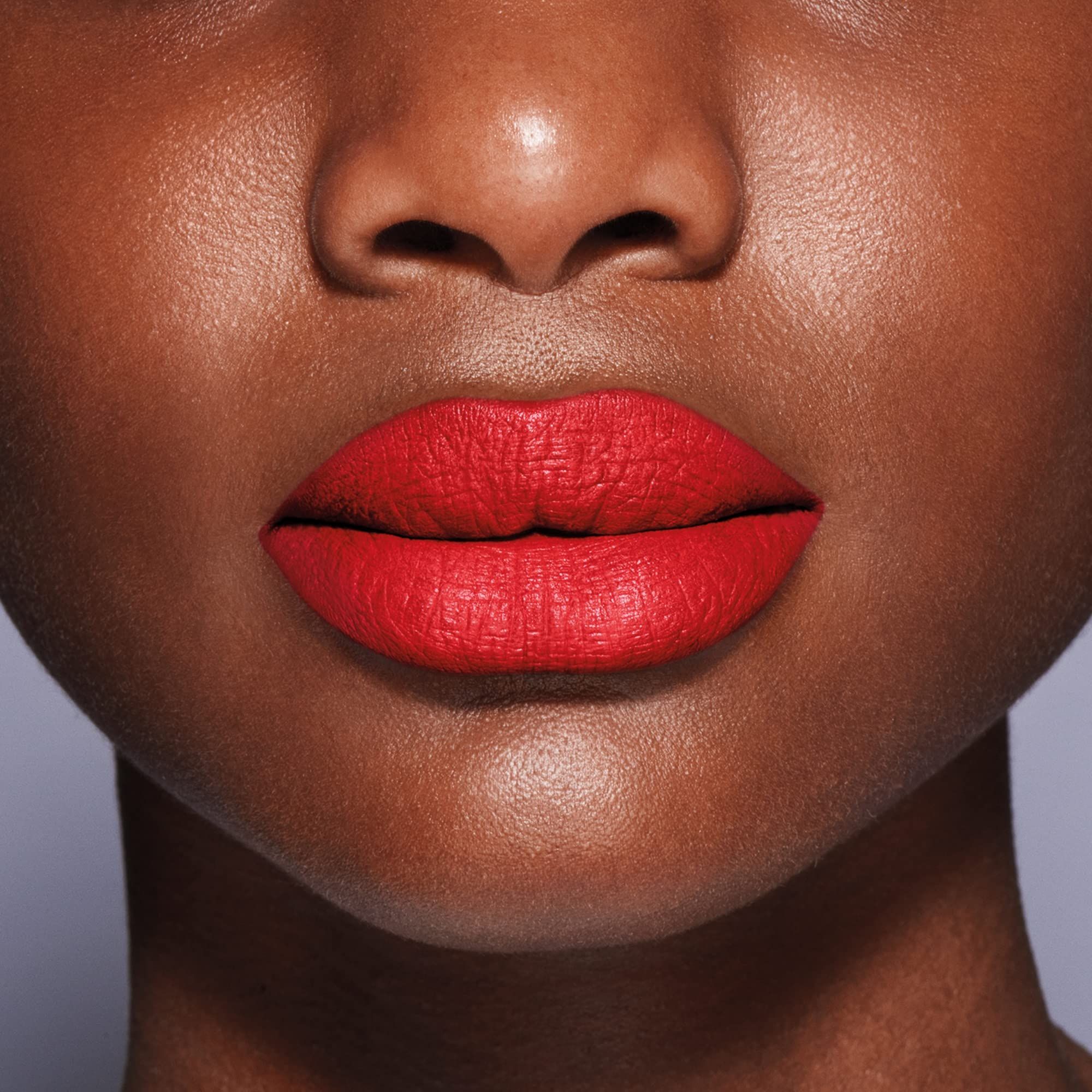 Primo piano di labbra con rossetto rosso. Texture opaca, applicazione uniforme.