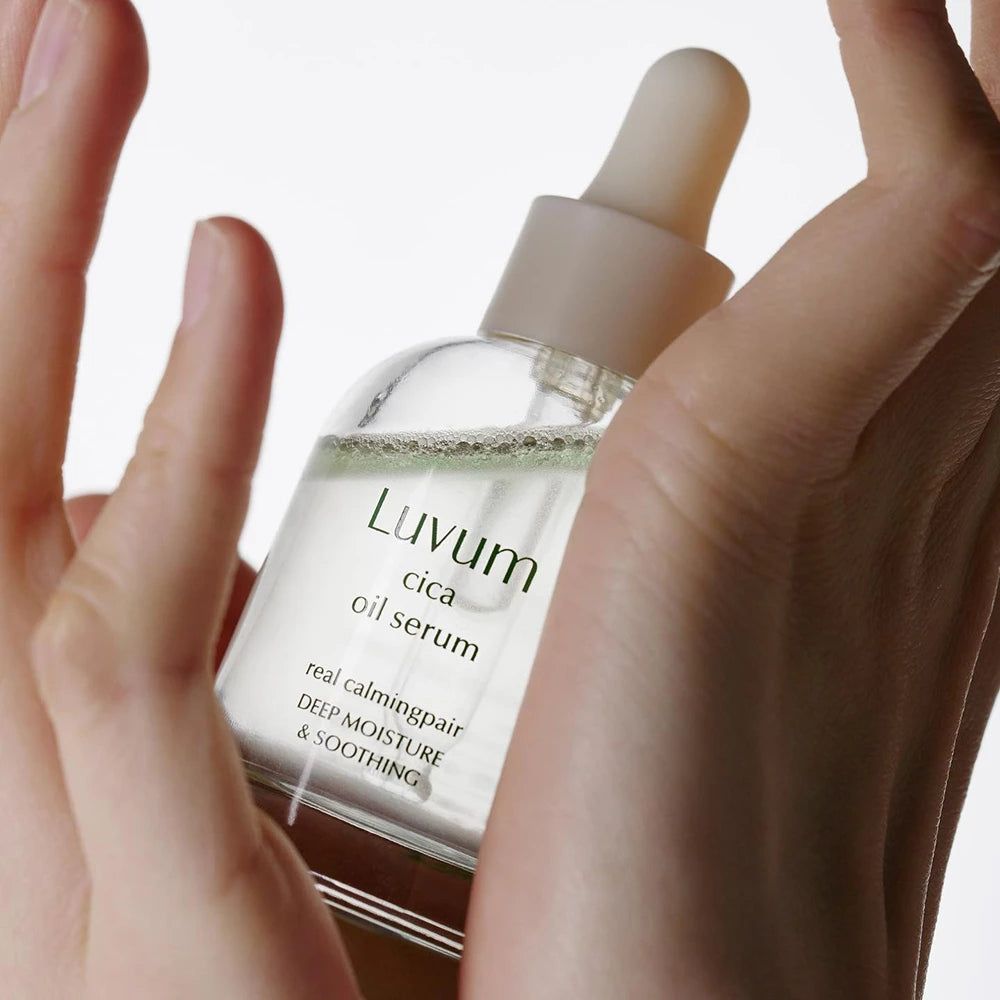 Mani che tengono una bottiglia di siero. Scritta: Luvum cica oil serum. Testo: real calming repair, deep moisture & soothing.
