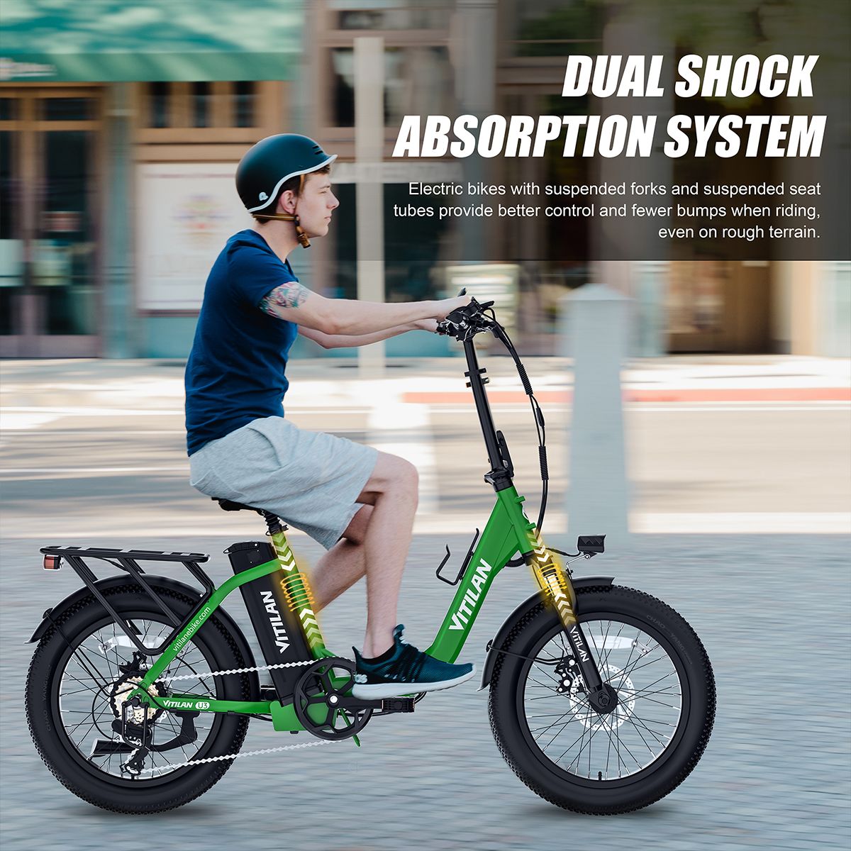 E-bike verde in movimento. Uomo che guida su strada. Sistema di assorbimento degli urti. Logo VITILAN visibile.