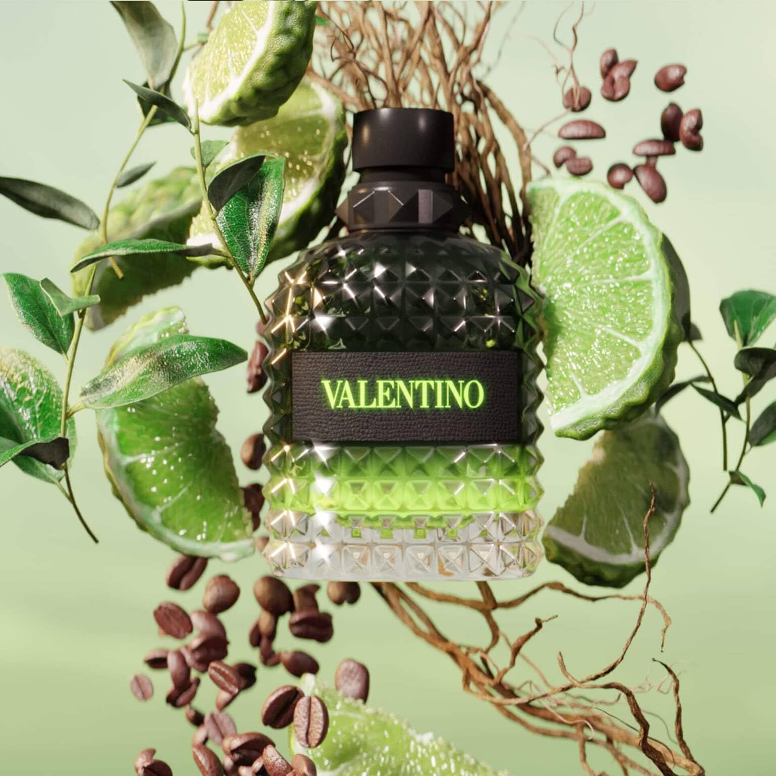 Profumo verde Valentino, circondato da fette di lime, chicchi di caffè e foglie. Tappo nero, scritta verde.