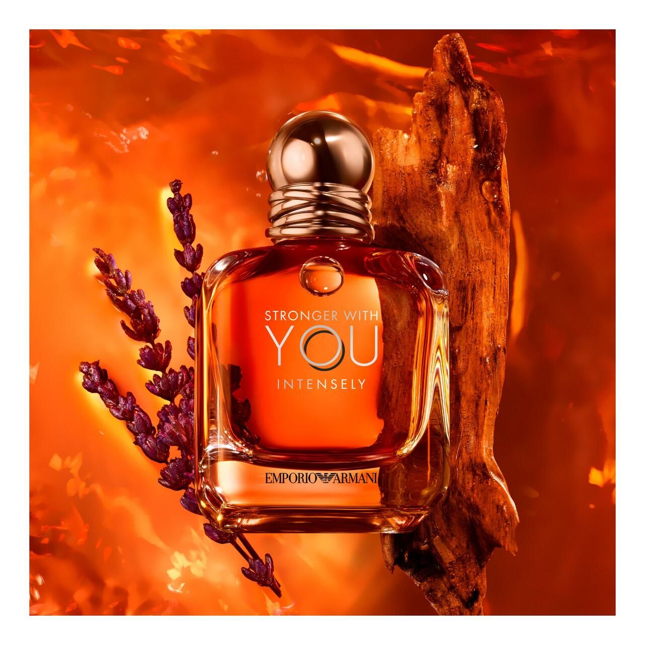 Emporio Armani Stronger With You Intensely. Flacone su sfondo arancione. Con lavanda e legno.