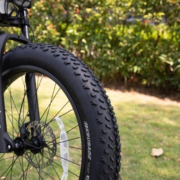 Pneumatico bici nero con battistrada scolpito. Marchio: KRUSADE. Parte della ruota anteriore.