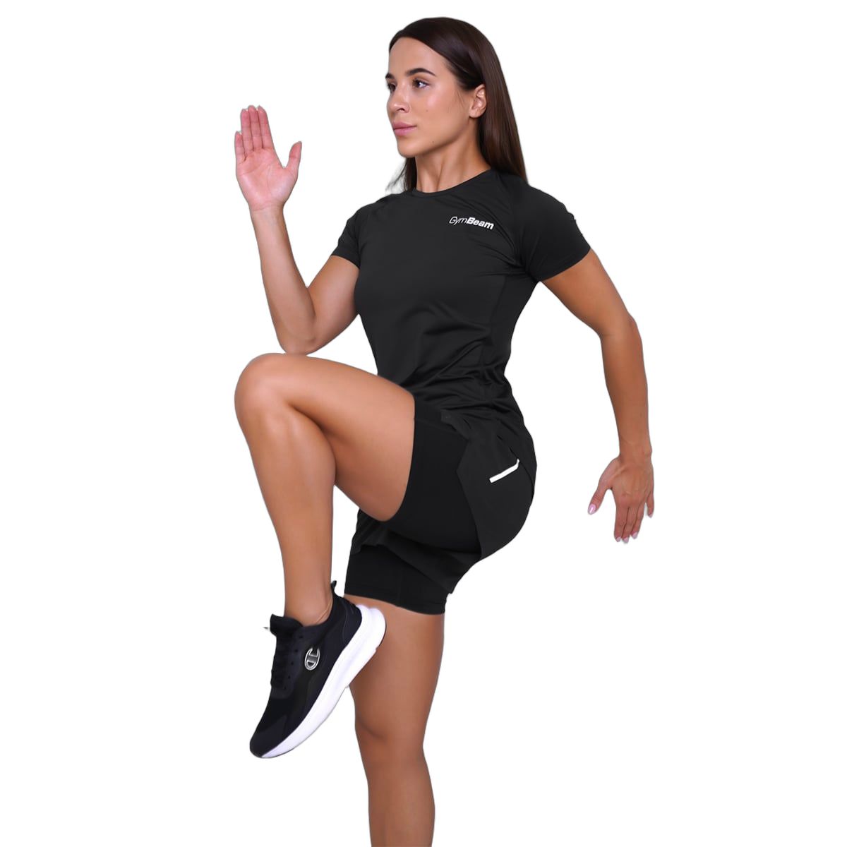 Donna con pantaloncini neri 2-in-1 e maglietta, solleva un ginocchio.