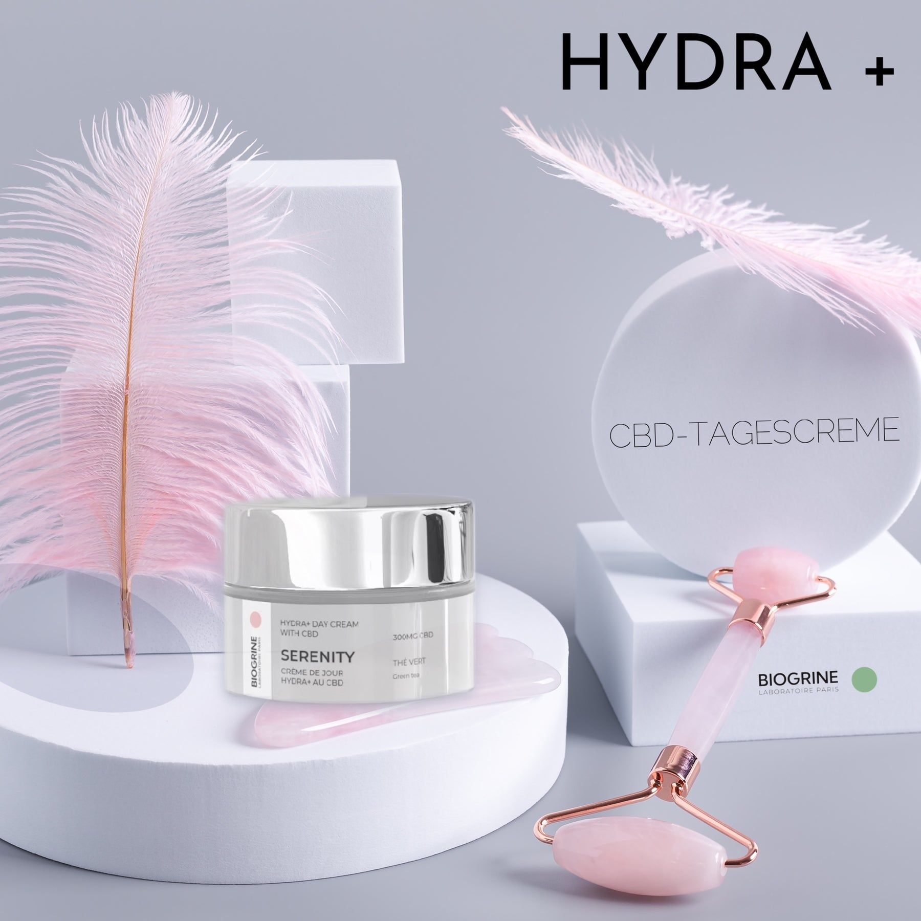 Vaso di crema, rullo di giada e piedistallo. Testo: Hydra+. Crema giorno al CBD. Piuma.