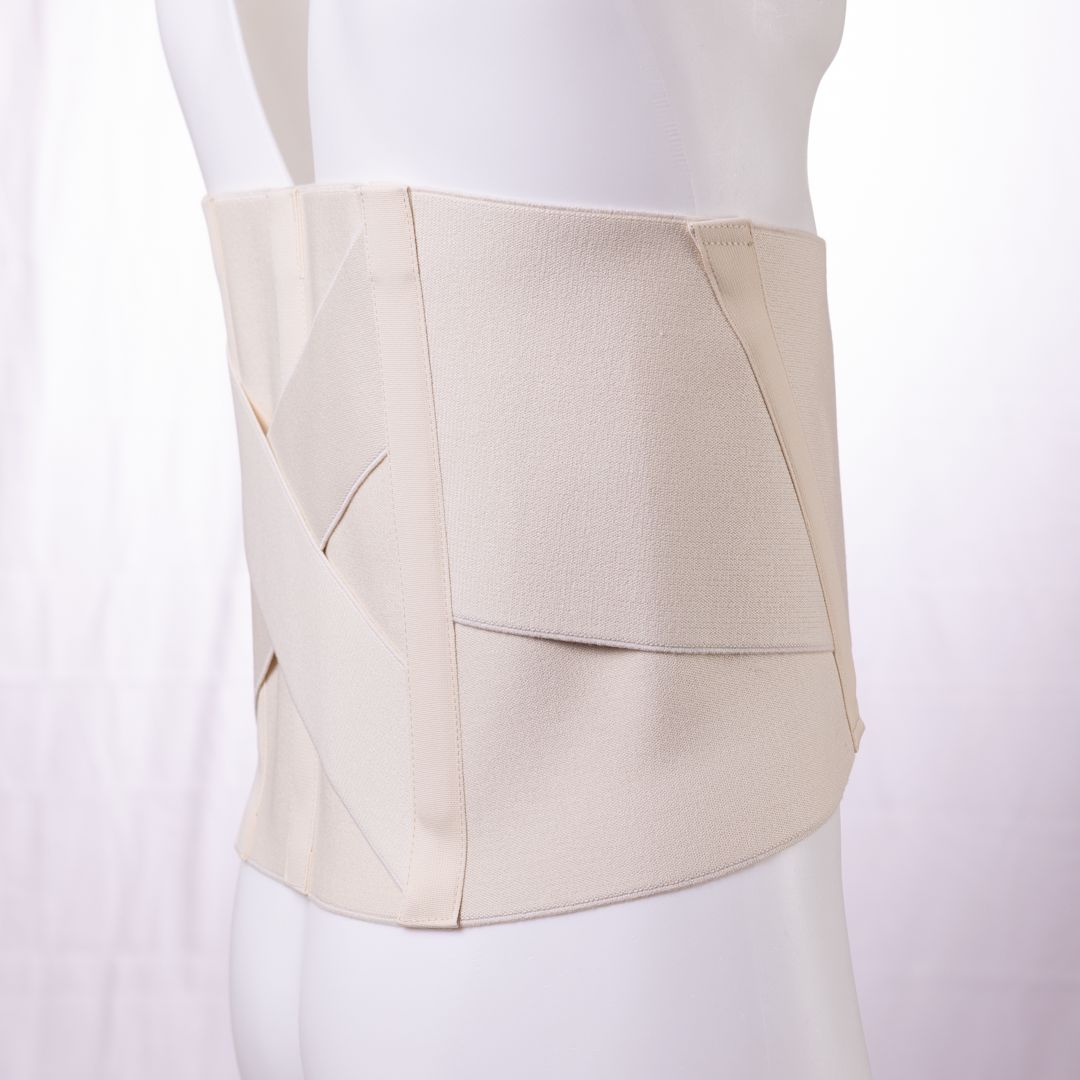Cintura di supporto lombare beige su manichino. Vista laterale. Cinghie incrociate e chiusura a velcro.