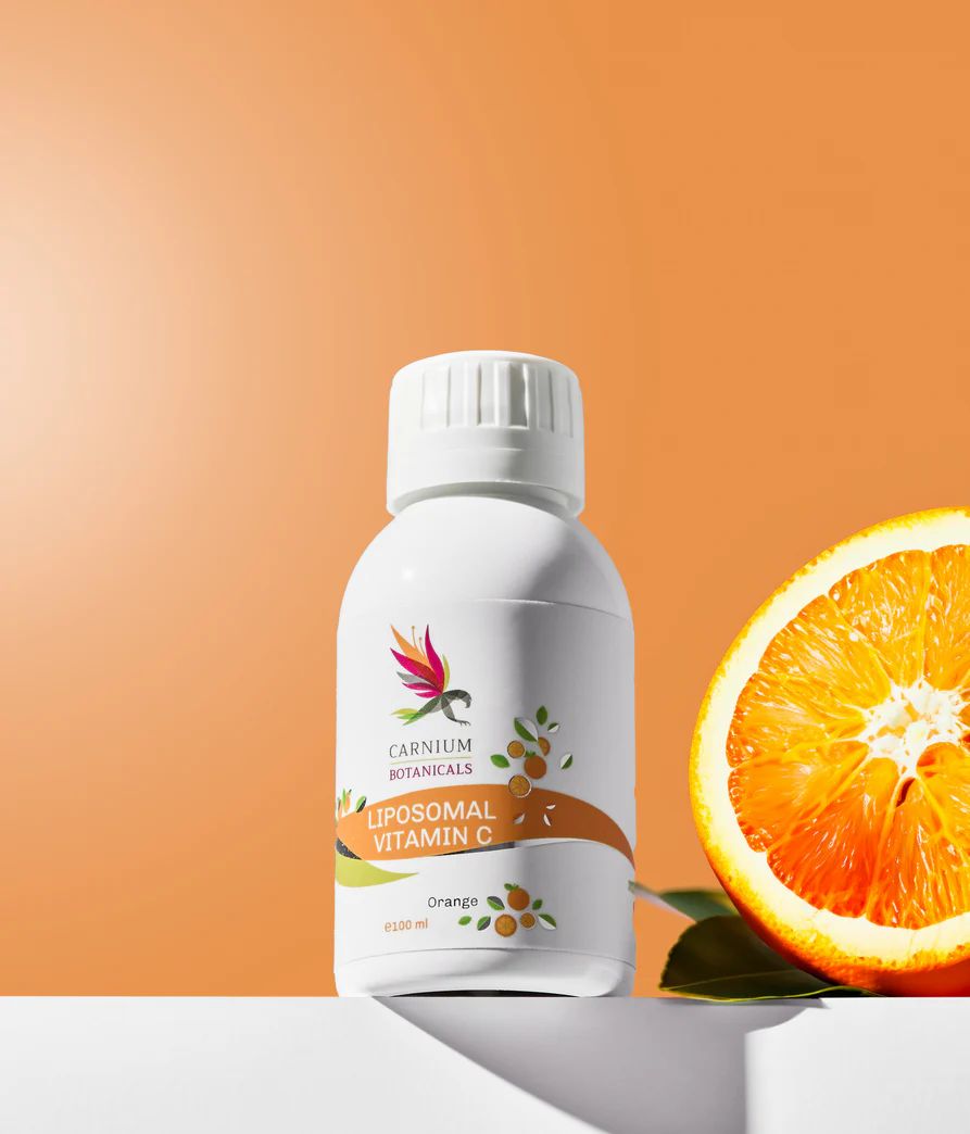 Flacone bianco con etichetta gialla. Scritta: Carnium Botanicals Liposomal Vitamin C. Arancia accanto.
