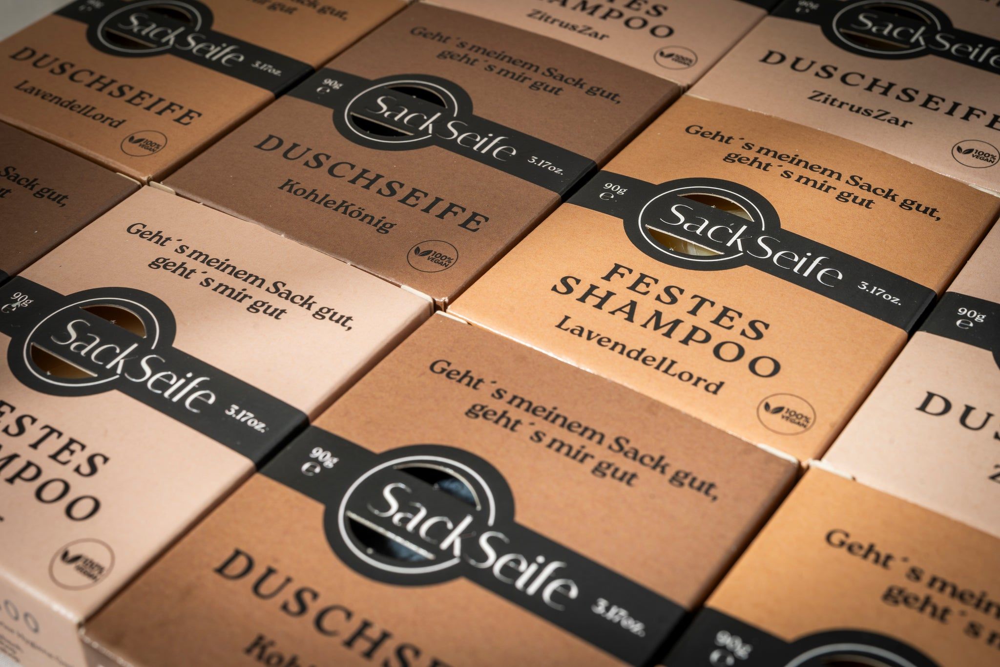Diverse confezioni di prodotti SackSeife. Scritta: SackSeife, Shampoo solido, Sapone doccia.