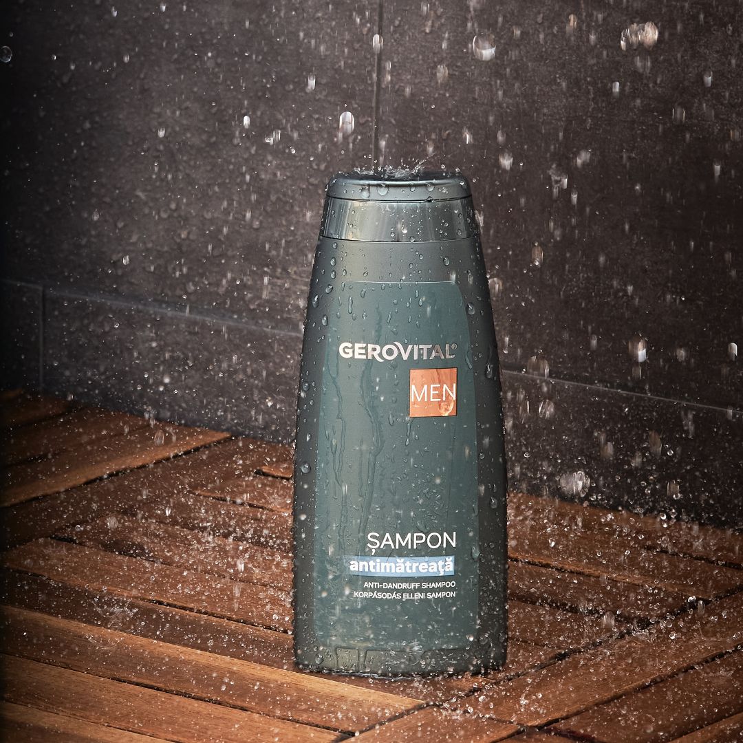 Flacone di shampoo verde scuro con tappo nero. Scritta: Gerovital Men, Şampon antimătreață. Spruzzi d'acqua.