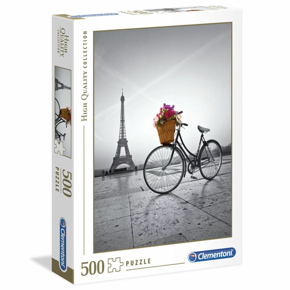 Scatola puzzle con immagine di bicicletta con cesto di fiori davanti alla Torre Eiffel. Marca Clementoni, 500 pezzi.