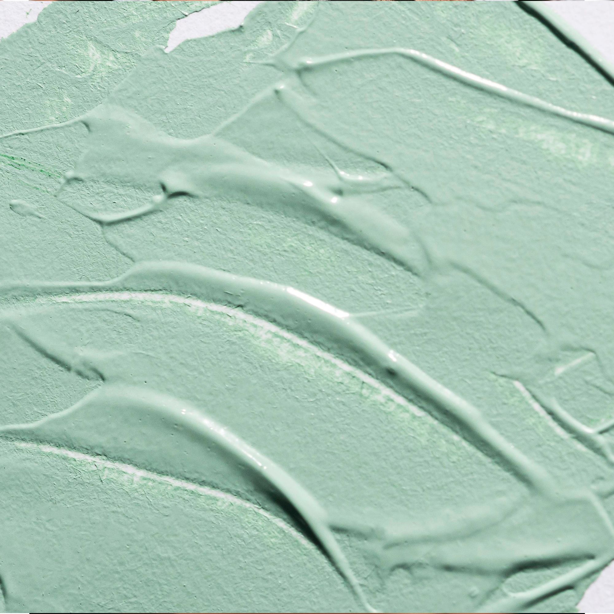 Primo piano di maschera all'argilla verde. Texture con tracce di applicazione.