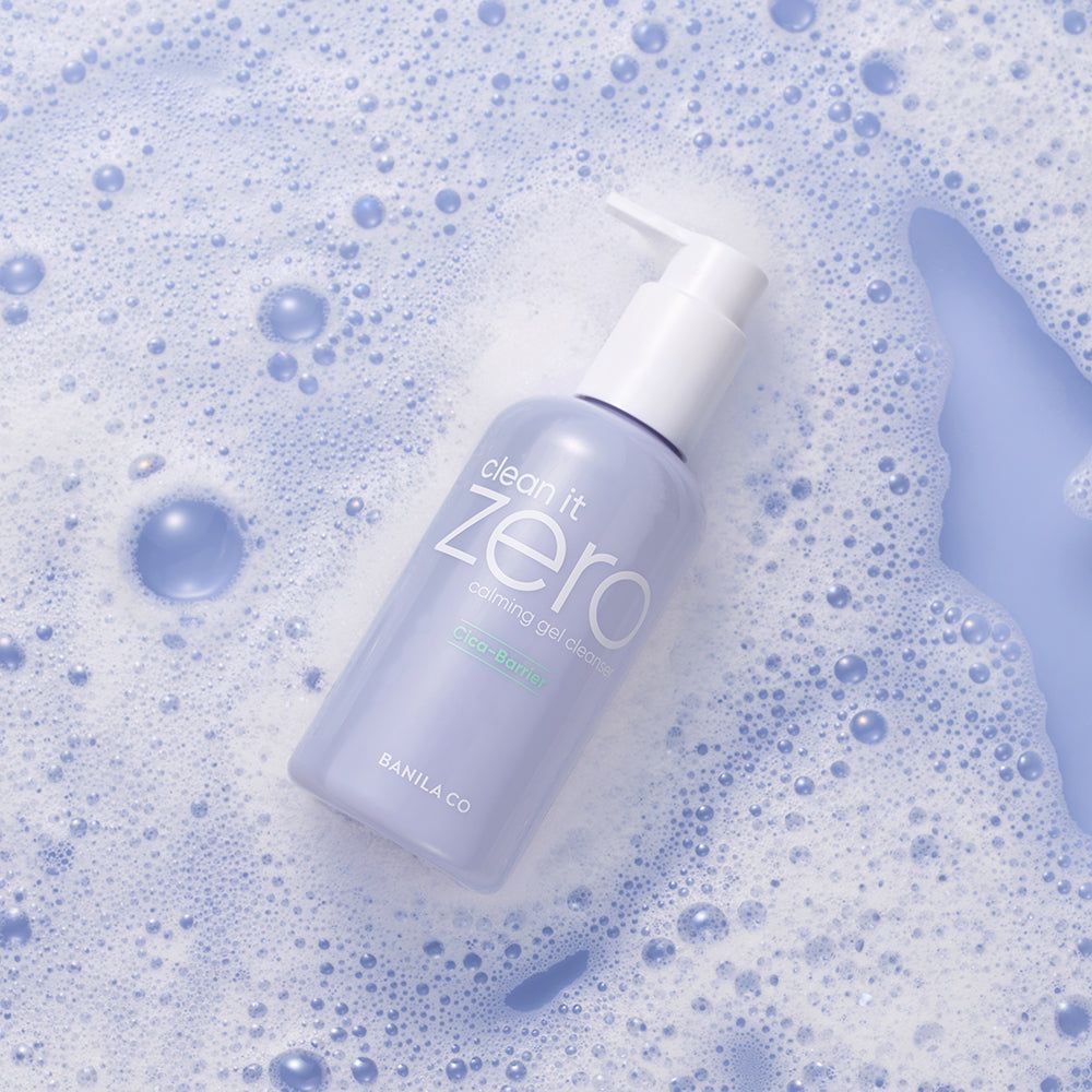 Flacone con dosatore a pompa. Scritta: Clean it Zero, Calming Gel Cleanser. Circondato da bolle di sapone.