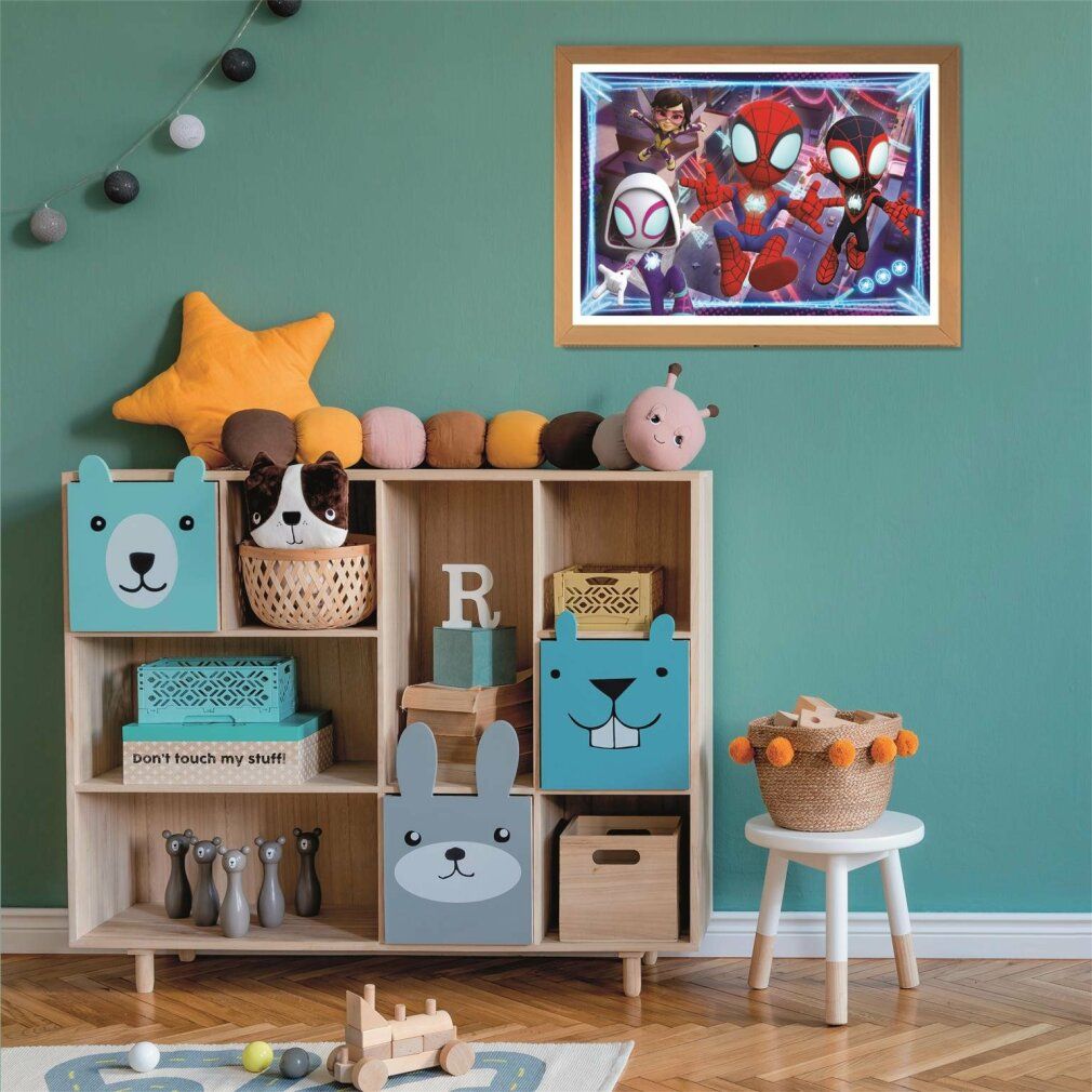 Puzzle Spidey & Friends incorniciato su parete verde. Mobili con giocattoli. Decorazioni: stelle, palline, cesto, coniglio, orso.