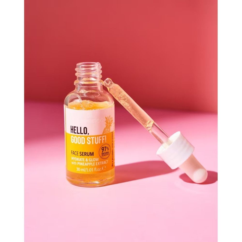 Flacone di siero aperto con pipetta. Scritta: Hello, Good Stuff! e Face Serum. Liquido giallo visibile. Pipetta accanto.
