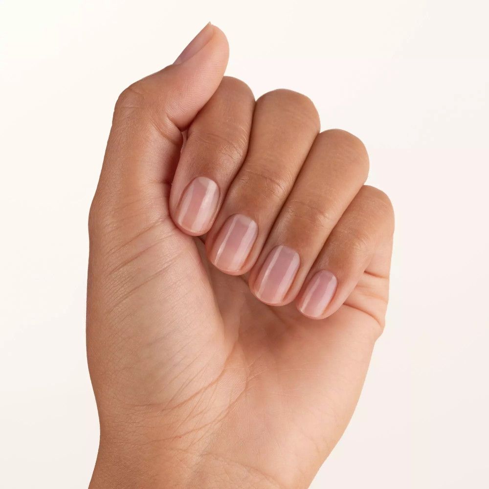 Mano con cinque unghie smaltate. Le unghie sono corte e di forma ovale. Lo smalto è trasparente.