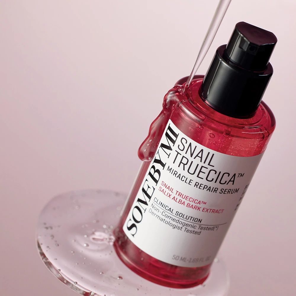Il Siero Riparatore Miracle Snail Truecica di SOMEBYMI viene versato su una superficie di vetro.