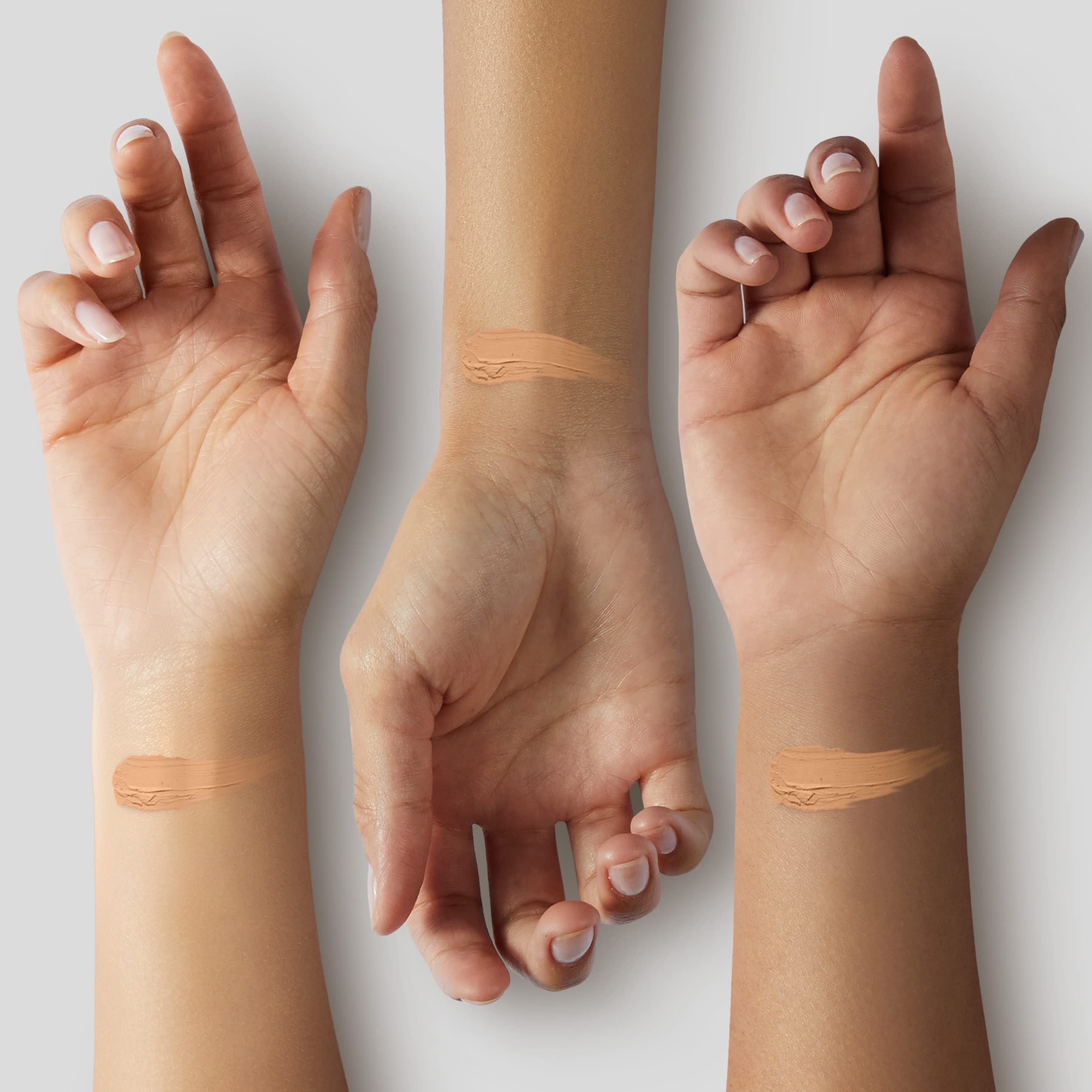Tre mani con strisce di prova di fondotinta in diverse tonalità di pelle. Prodotto applicato sul dorso della mano.
