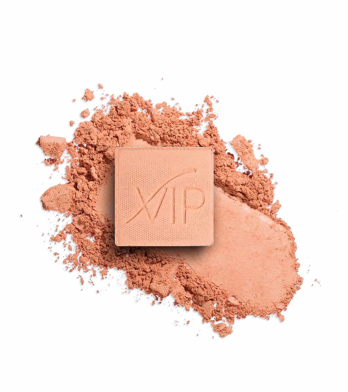 Un blocco di fard quadrato color pesca con il logo "VIP" impresso su una polvere di fard sfusa.