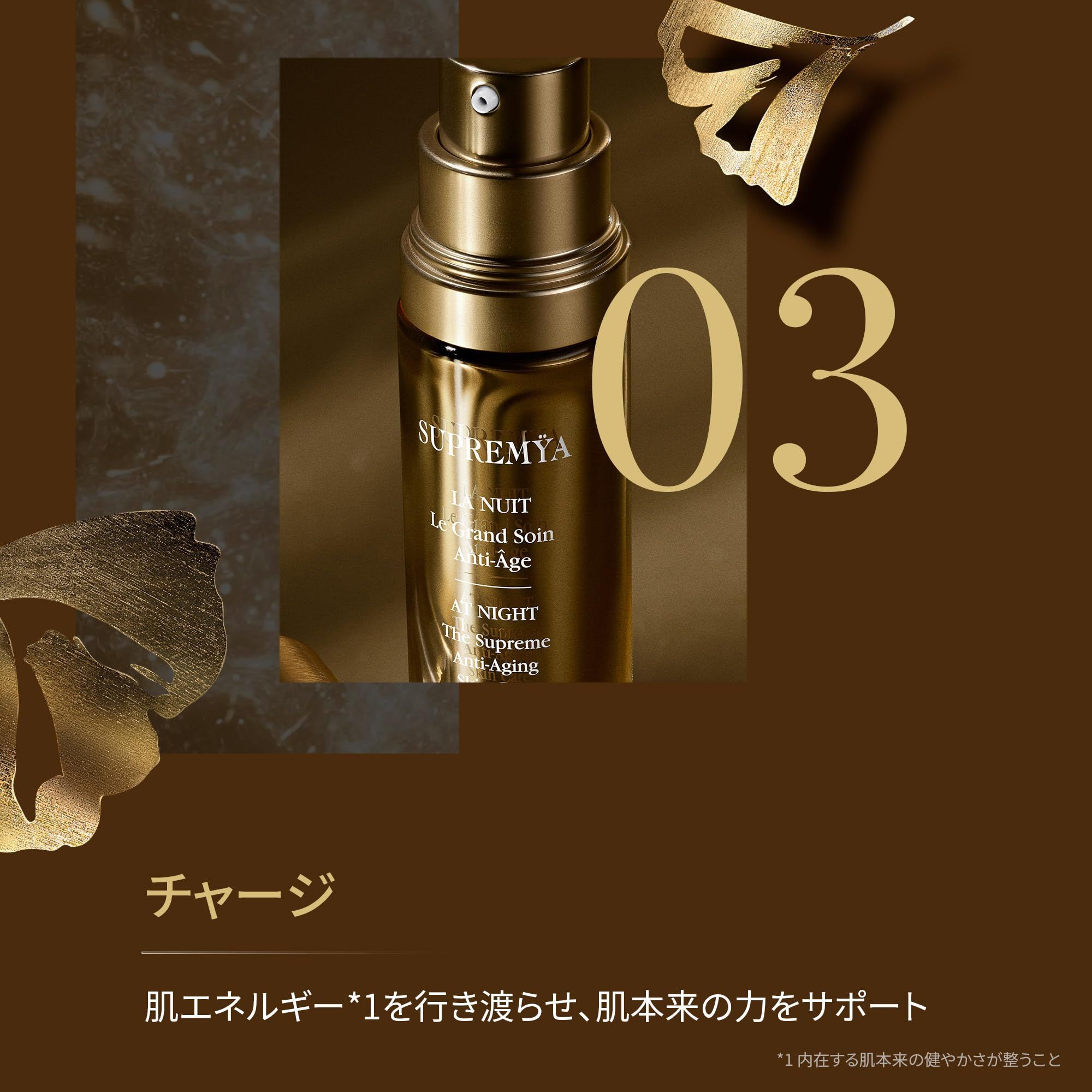 Flacone dorato con vaporizzatore. Scritte: Supremÿa, Le Grand Soin Anti-Age, AT NIGHT, The Supreme Anti-Aging. Sfondo: marrone, foglie dorate, numero 03.