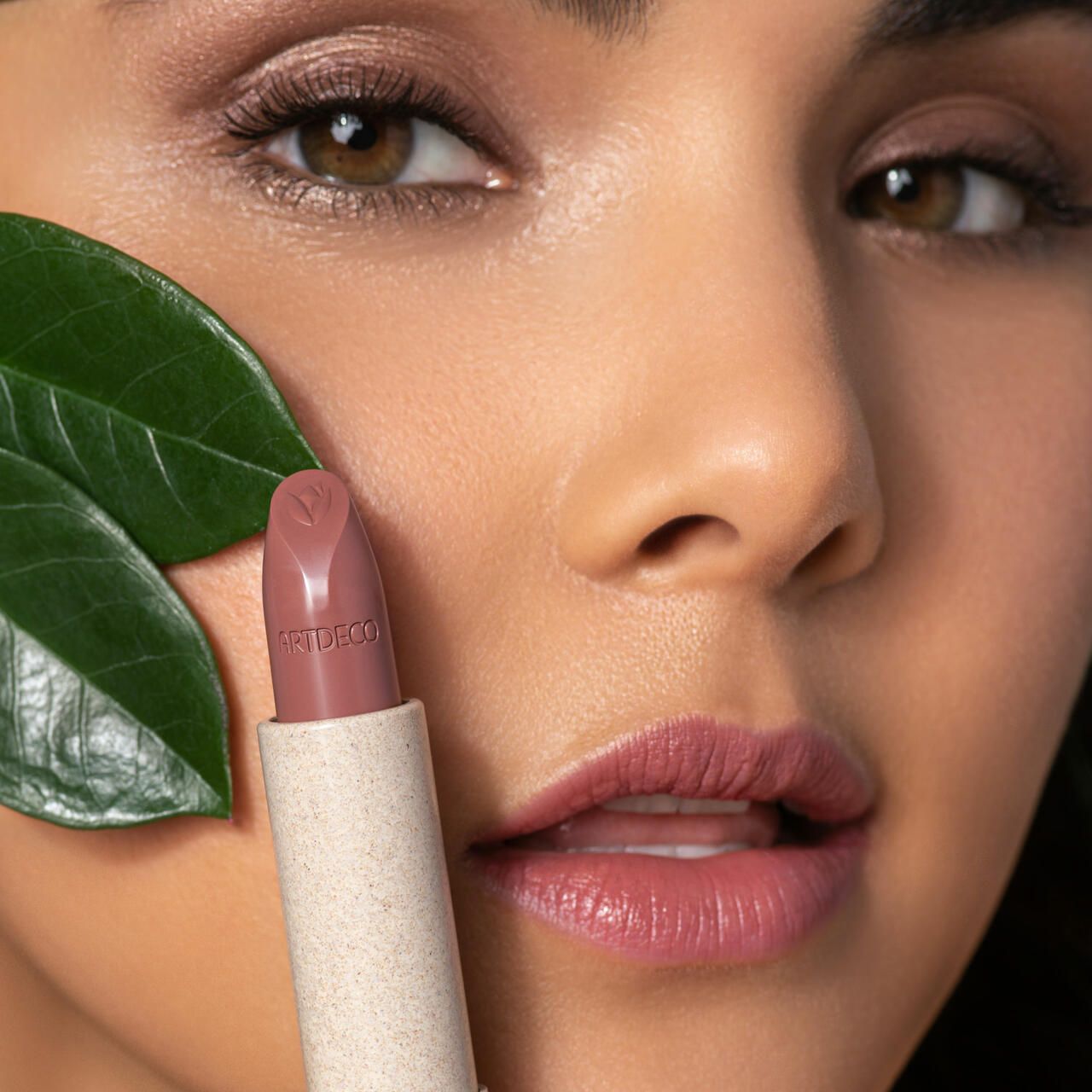 Donna con rossetto. Il rossetto aperto mostra il marchio "ARTDECO".