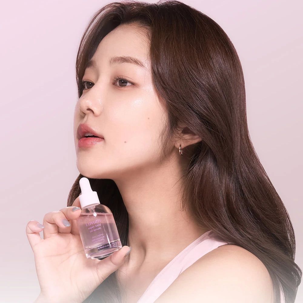 Donna tiene flacone di siero. Flacone con contagocce. Liquido rosa visibile. Pelle chiara.