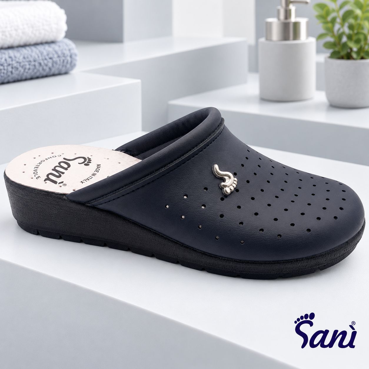 Zoccolo blu scuro traforato con logo a forma di piede argentato. Tacco di 4 cm. Soletta in pelle.