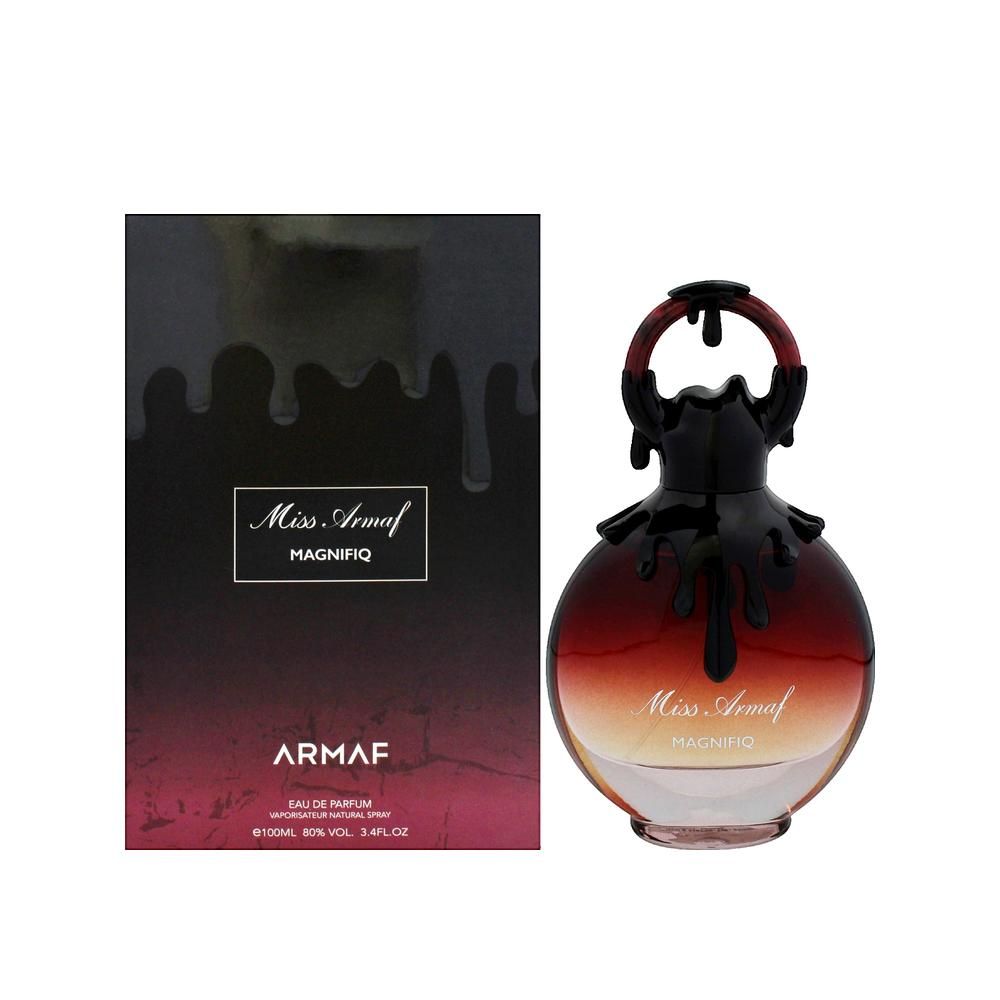 Flacone di profumo e confezione. Flacone rotondo, rosso-marrone, con tappo nero. Confezione nera con testo.