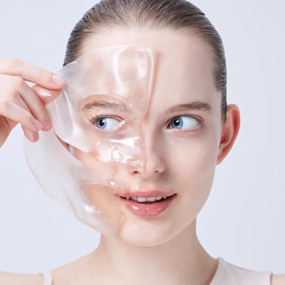 Donna che rimuove una maschera idrogel dal viso. Primo piano.