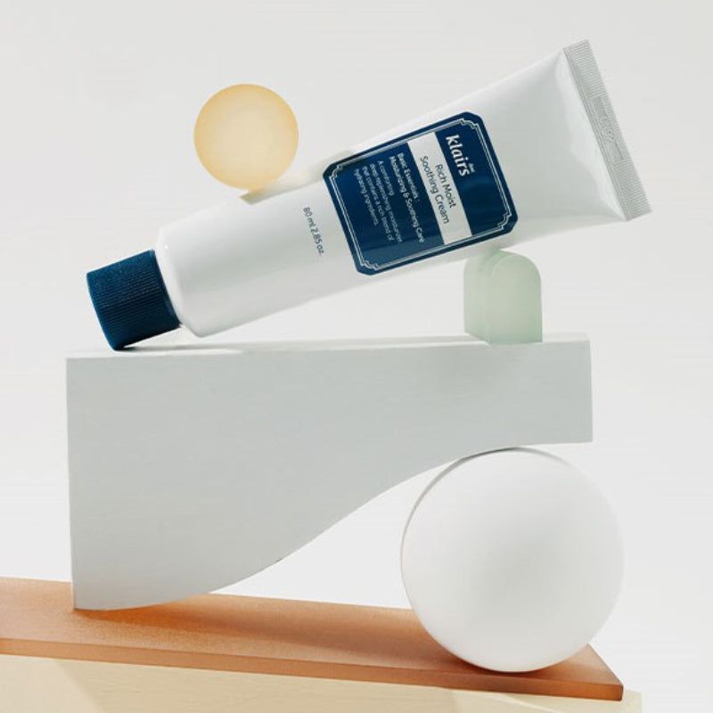 Tubo bianco con tappo blu. Scritta: klairs Rich Moist Soothing Cream. 80 ml. Su piedistallo.