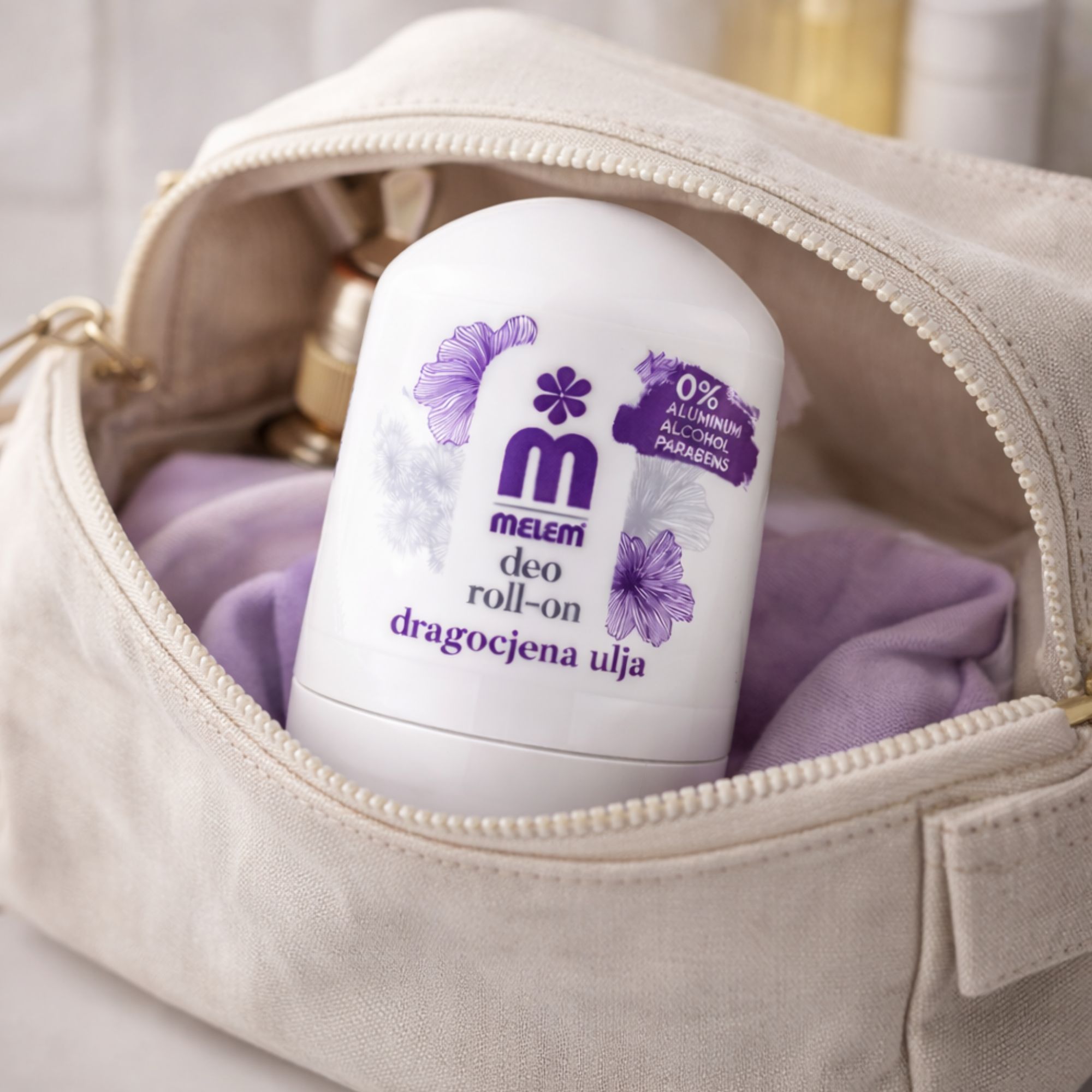 Roll-on bianco in un beauty case beige. Scritta: Melem Deo Roll-On. Tessuto viola accanto.