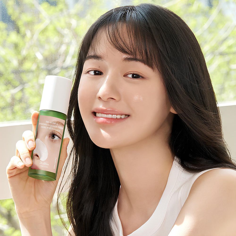 Una donna tiene in mano una bottiglia di Dr. Althea Premium Quick Step Sebum Cleanser.