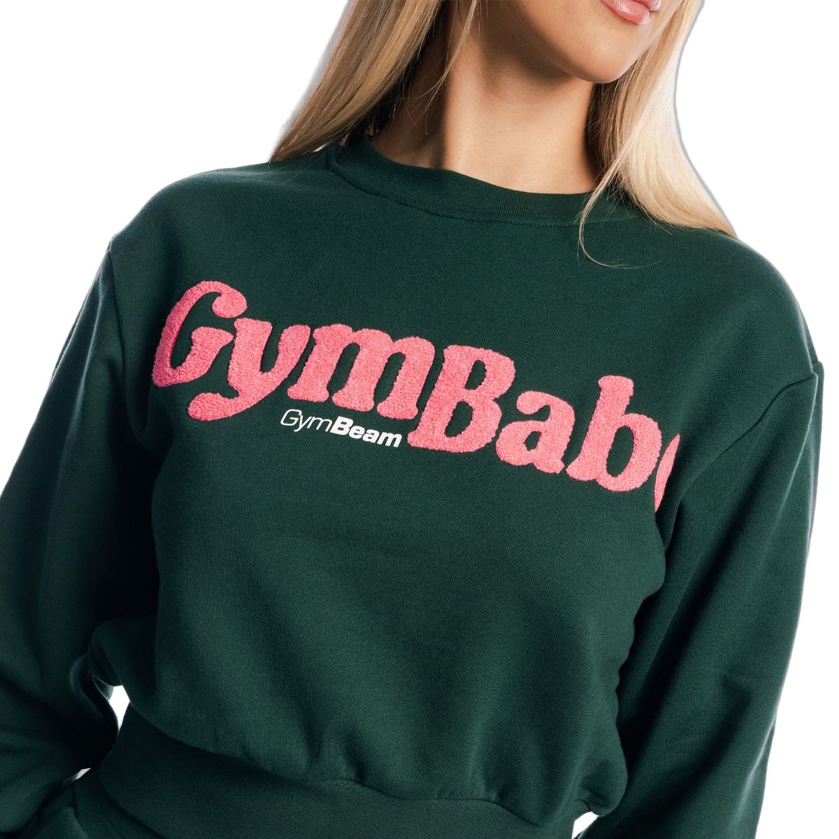 Primo piano della scritta rosa 'GymBaby' su un maglione cropped da donna verde a maniche lunghe.