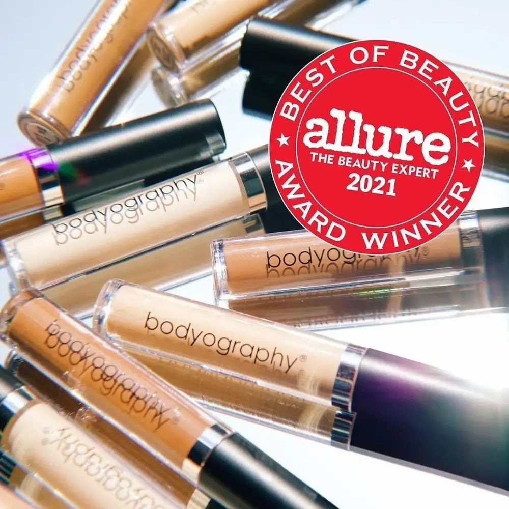 Diversi tubetti di correttore con logo Bodyography. Adesivo rosso con 'Best of Beauty' e 'Allure'.