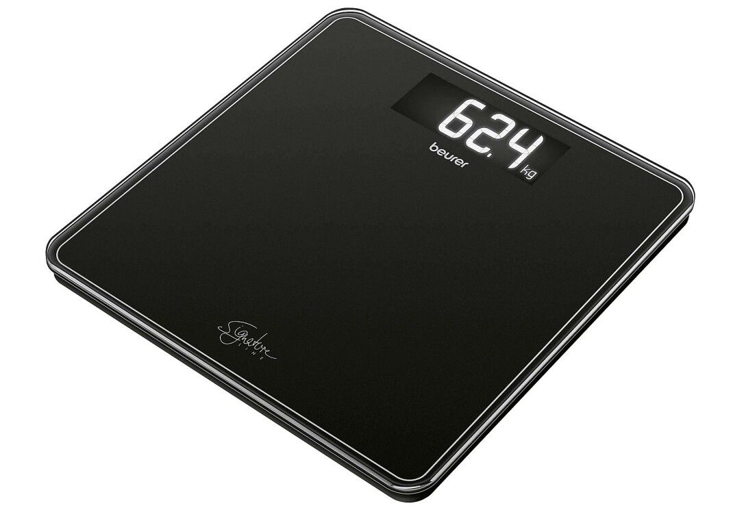 Bilancia nera con display digitale. Mostra 62,4 kg. Marchio: beurer. Logo Signature Line.
