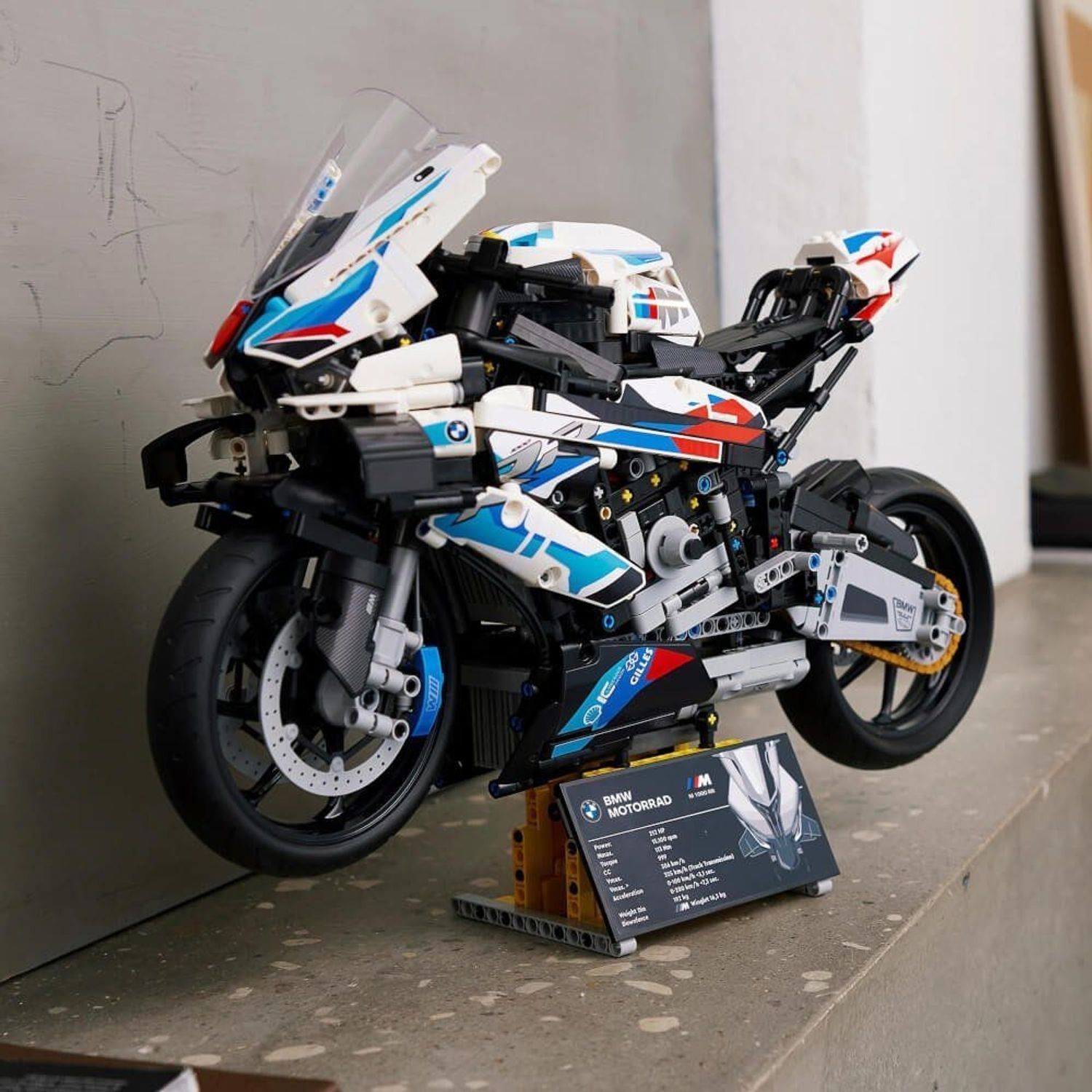 Modello moto LEGO Technic BMW M 1000 RR completato. Posizionato su un piedistallo. Con targhetta informativa.