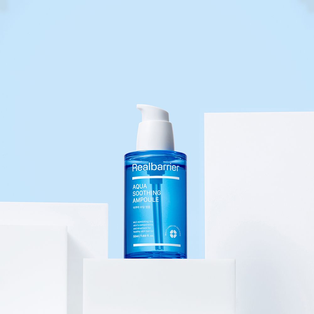 Siero blu con erogatore bianco su piedistallo bianco. Scritta: Realbarrier Aqua Soothing Ampoule.